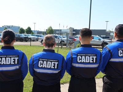 Brandon Community Cadets - four members facing backward with the cadet logo showing on their uniforms